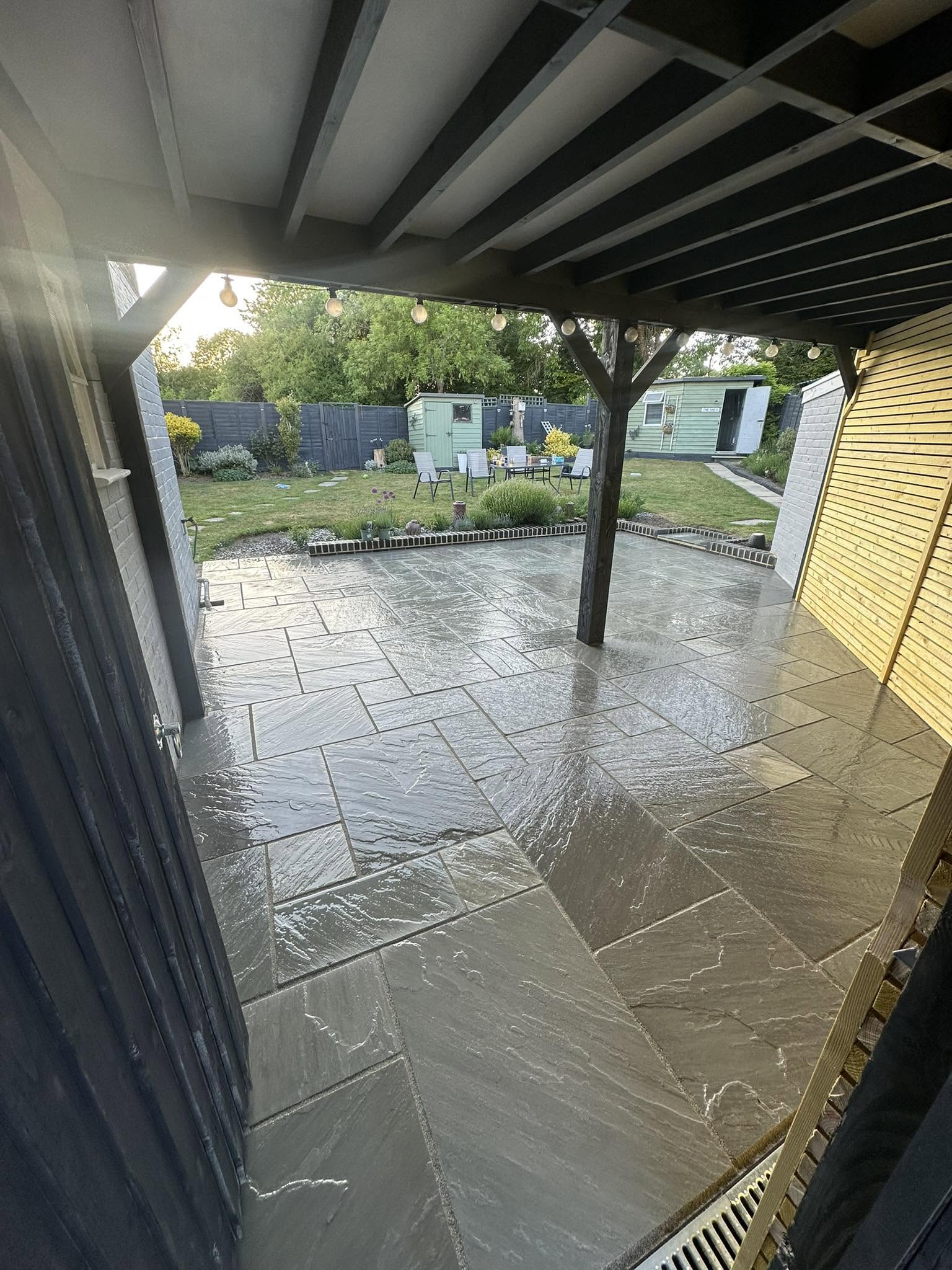 Indian sandstone patio with pergola and festoon lighting, built by TJH Landscapes in Sevenoaks