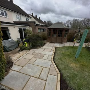 Garden with new sandstone paving leading to a summerhouse